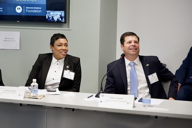Two smiling people sit at a desk at the PERF Prosecutor Police Collaboration Meeting. 